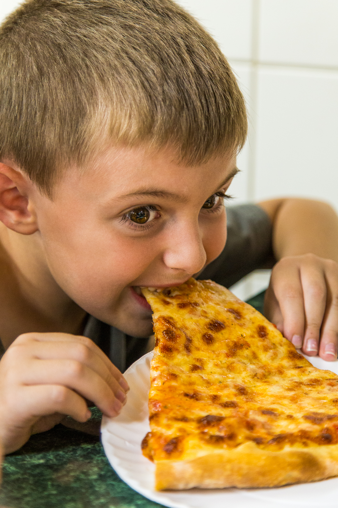 Boy eating pizza slice